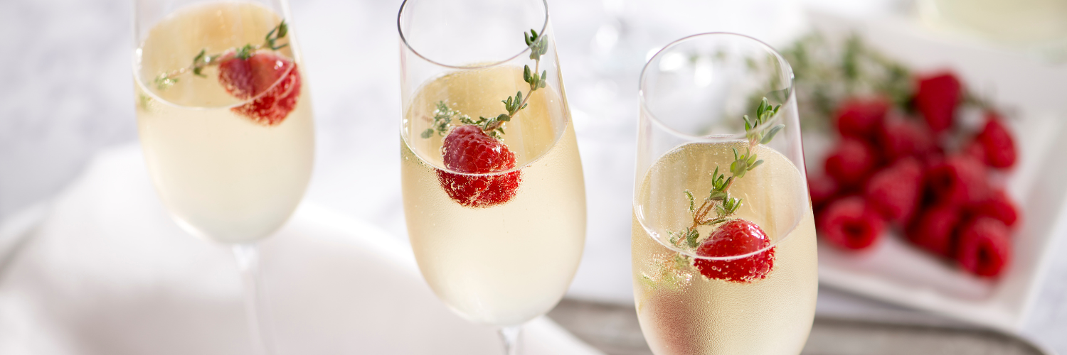 3 glasses of sparkling nonalcoholic white wine with raspberries and sprig of garnish