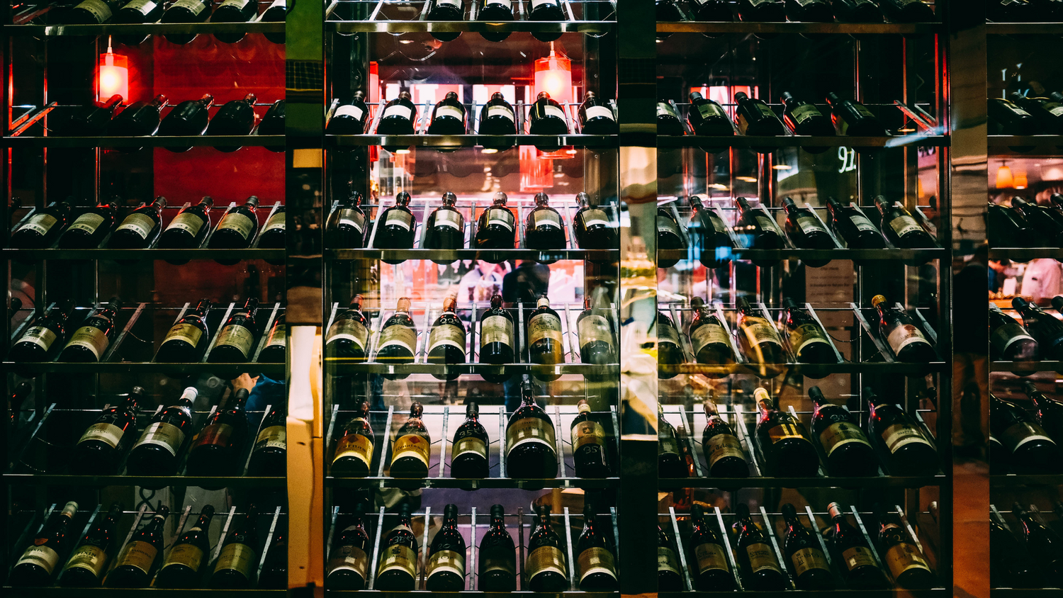 Wine bottles on glass backlit shelf